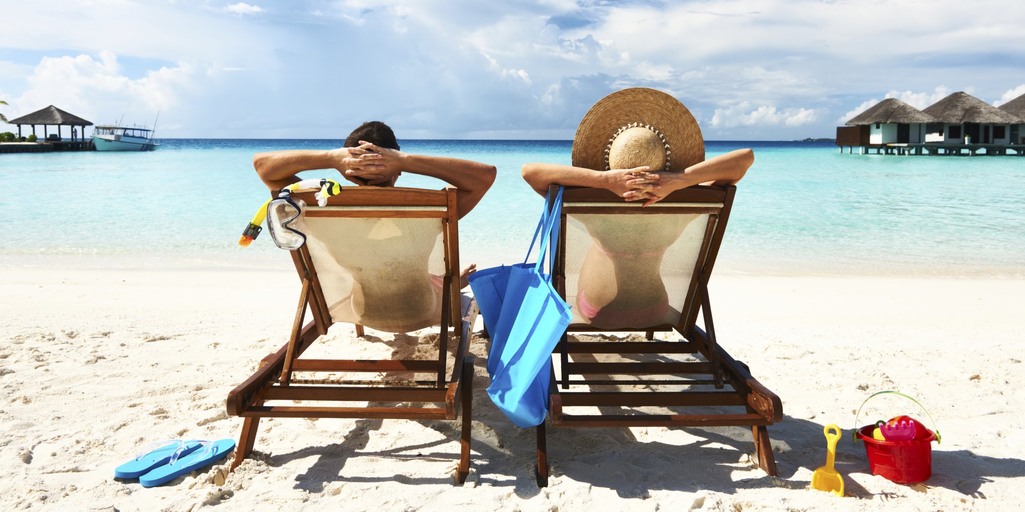 Two people sitting in chairs on a beach vacation