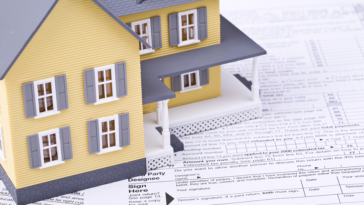 Photo of a model house sitting on top of a house tax form