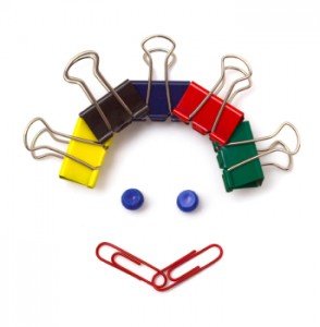 A smiley face made of binder clips (for hair), tacks (for eyes), and paperclips (for its smile)