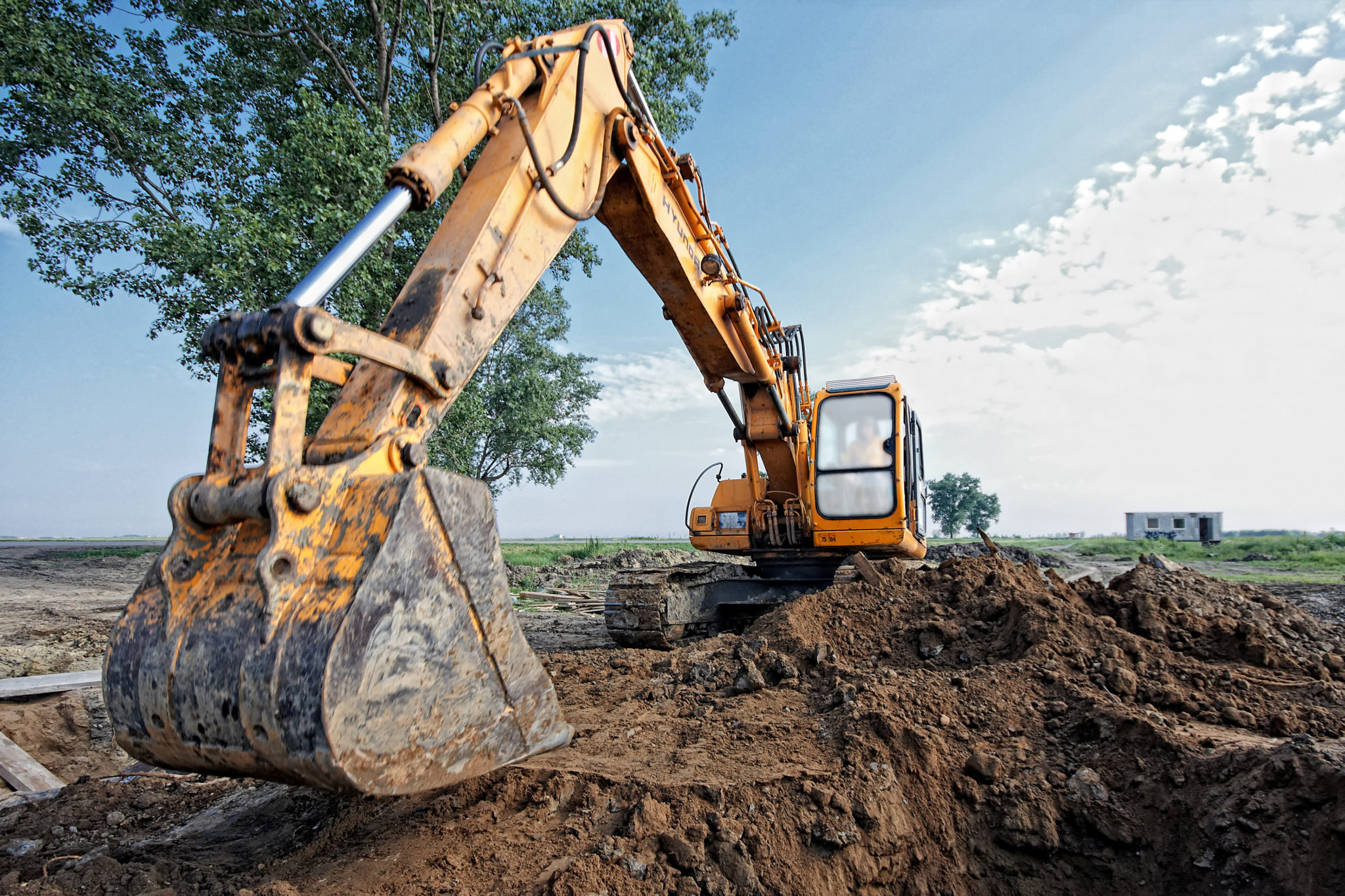 A photo of an excavator digging a trench for a pipeline.