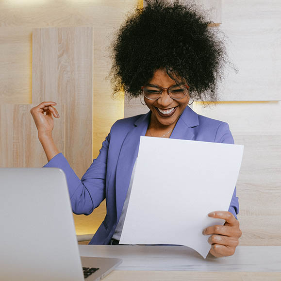 Photo of overly excited black woman smiling at paper