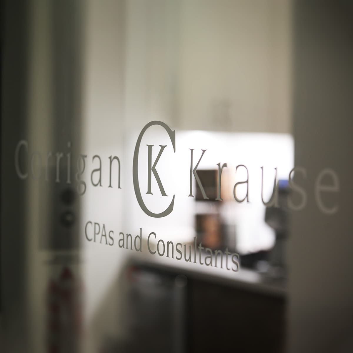 Photo of inside signage depicting the Corrigan Krause CPAs and Consultants logo on a glass pane